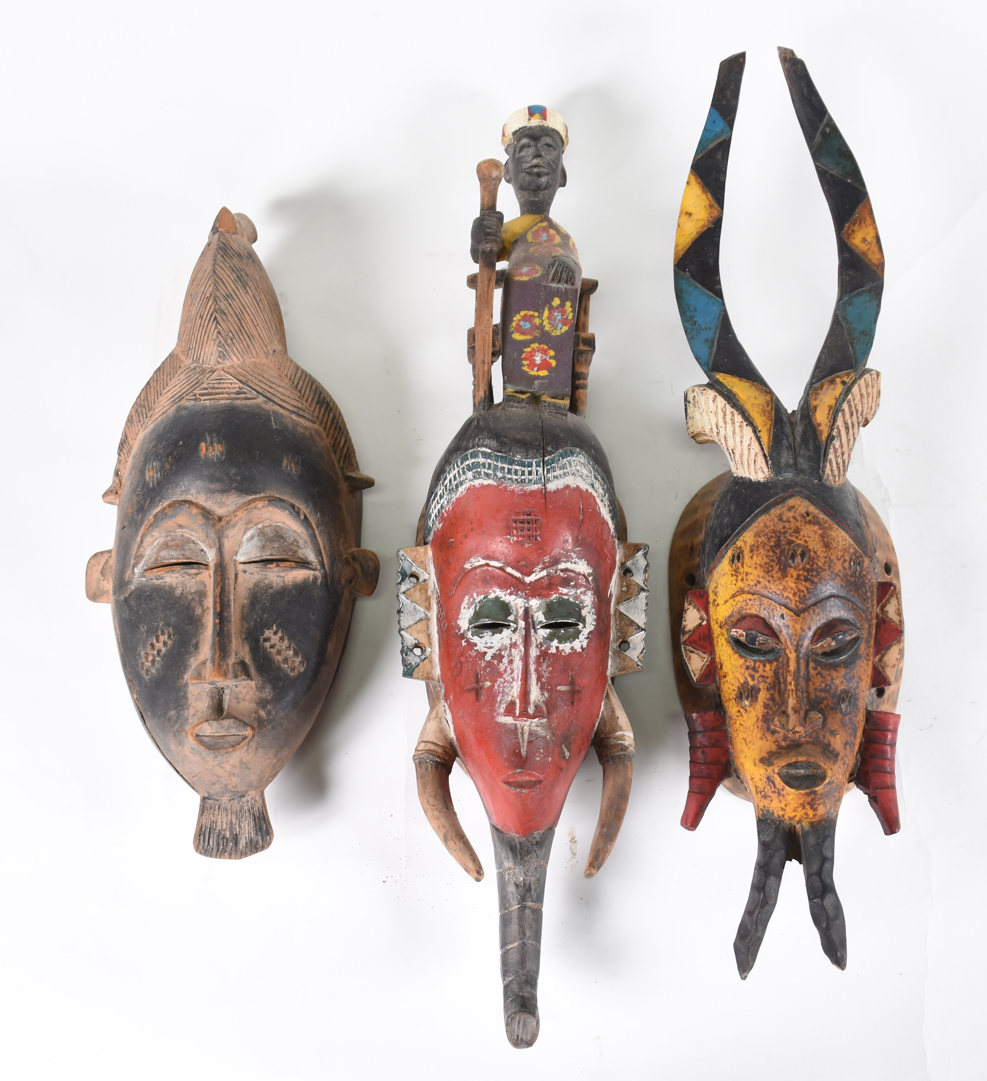 Três máscaras Africanas de madeira entalhada e policromada. - foto 1 de 2