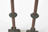 Par de castiçais de metal com bases decoradas c... - Par de castiçais de metal com bases decoradas com figuras de animais estilizados. Metal com desgastes.