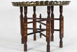 Mesa oriental com tampo de metal dourado e base... - Mesa oriental com tampo de metal dourado e base  de madeira articulada .