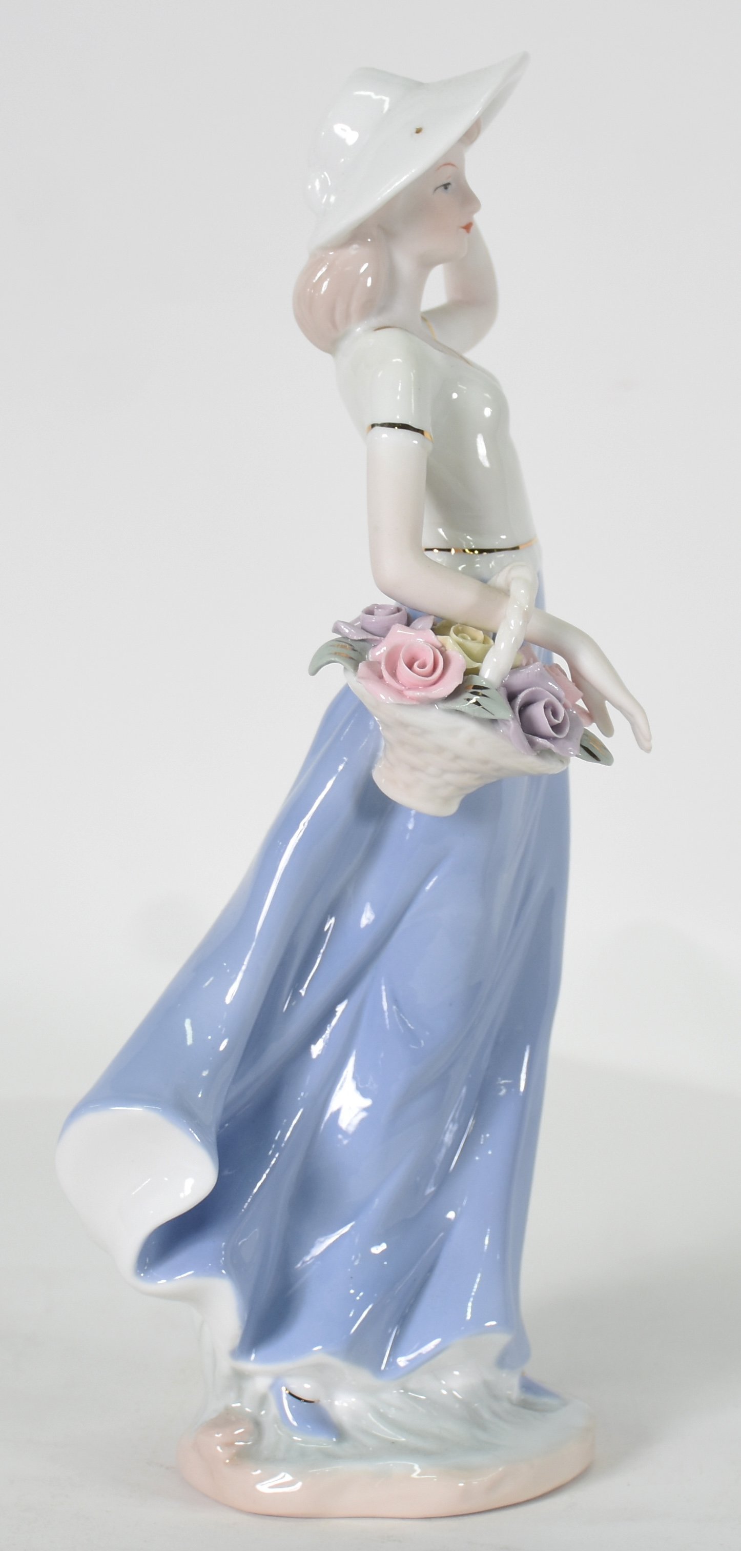 Escultura de porcelana representando mulher com cesto. - foto 1 de 4