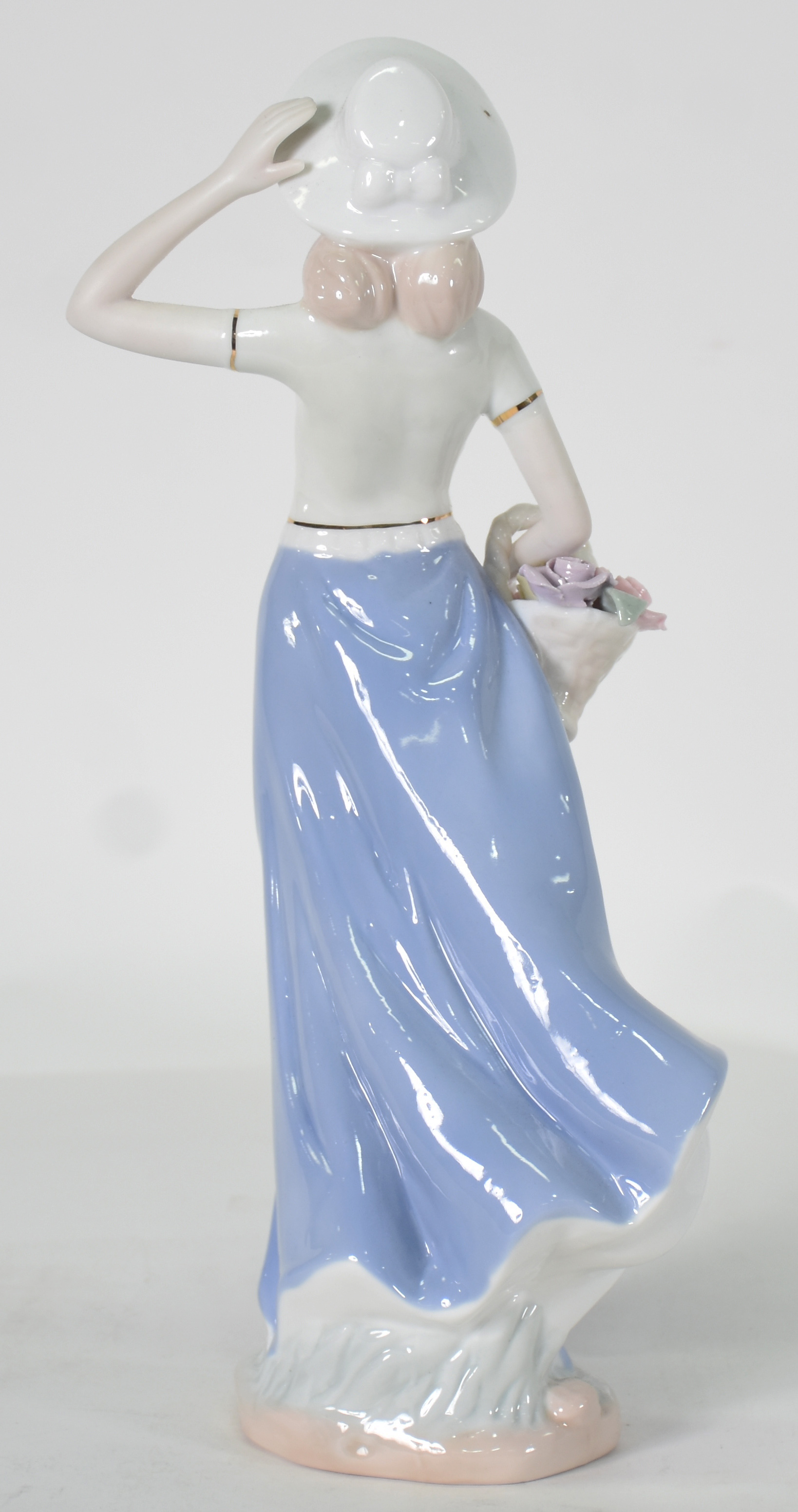 Escultura de porcelana representando mulher com cesto. - foto 3 de 4