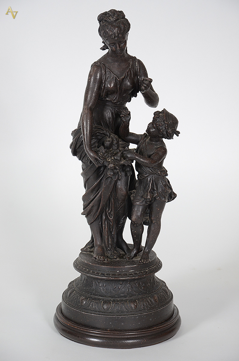 Escultura de petit bronze representando figura feminina com criança... - foto 1 de 4