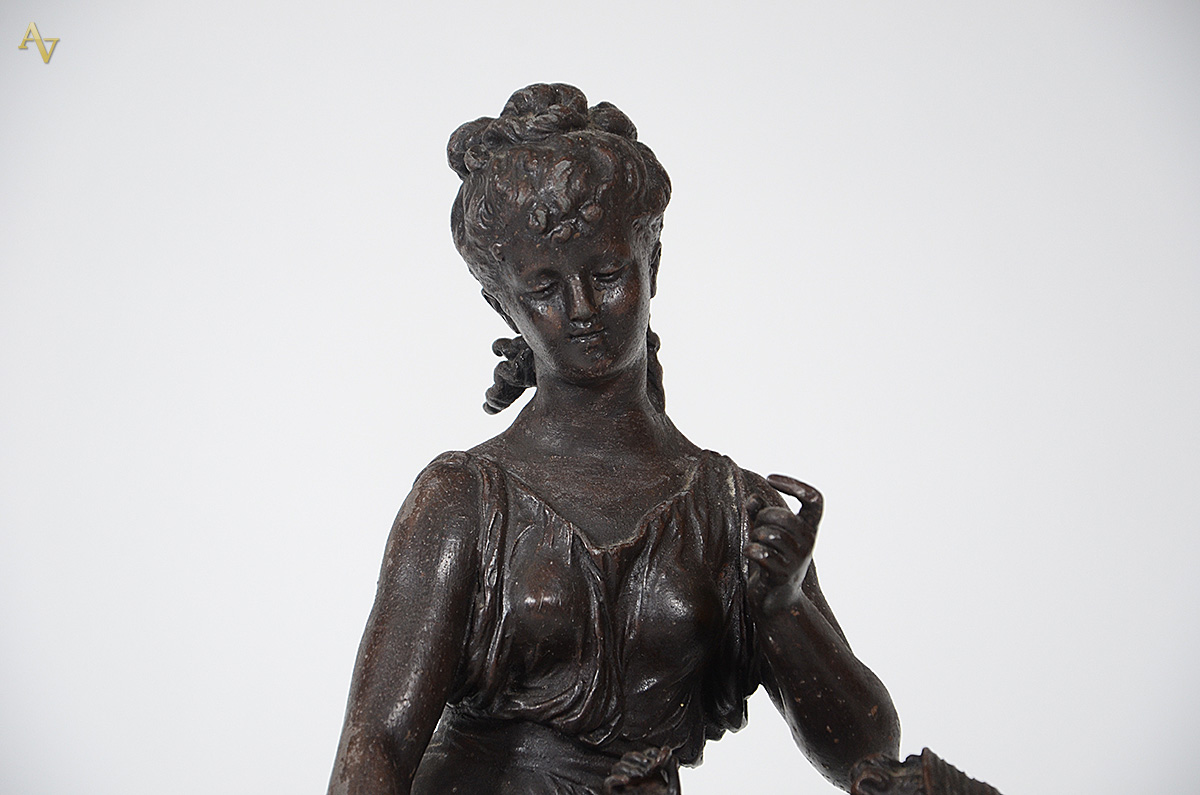Escultura de petit bronze representando figura feminina com criança... - foto 2 de 4