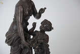Escultura de petit bronze representando figura ... - Escultura de petit bronze representando figura feminina com criança. Altura  total 56 cm.
