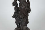 Escultura de petit bronze representando figura ... - Escultura de petit bronze representando figura feminina com criança. Altura  total 56 cm.