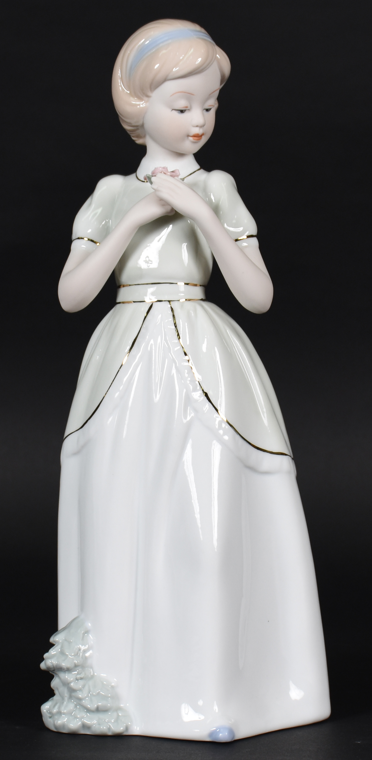 Estatueta de porcelana representando menina com flor . - foto 1 de 4