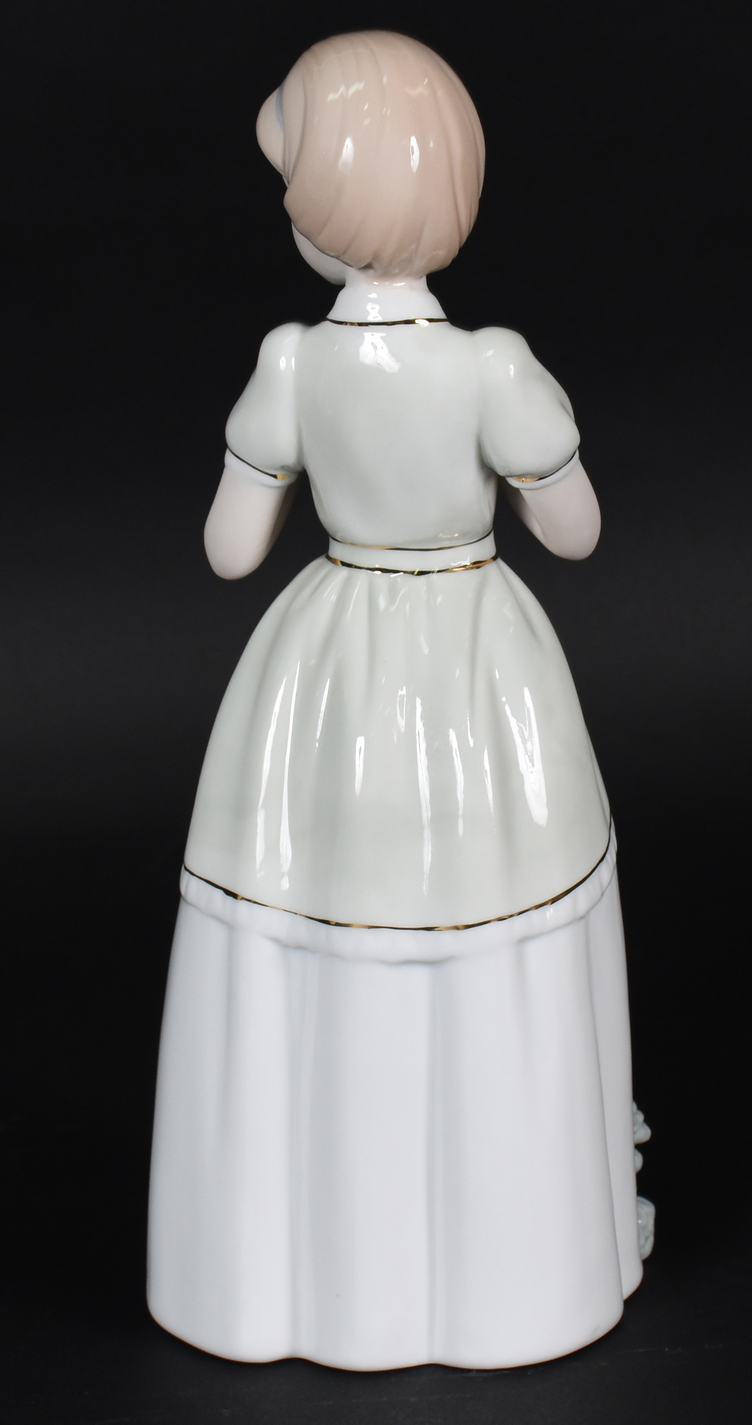 Estatueta de porcelana representando menina com flor . - foto 3 de 4