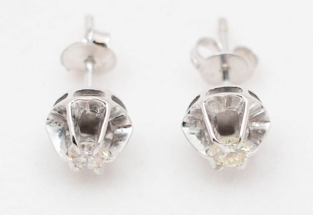 Par de brincos solitário de ouro branco com aproximadamente 0.40 ct...