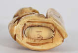 Netsuke de marfim representando figura com placa. - Netsuke de marfim representando figura com placa.