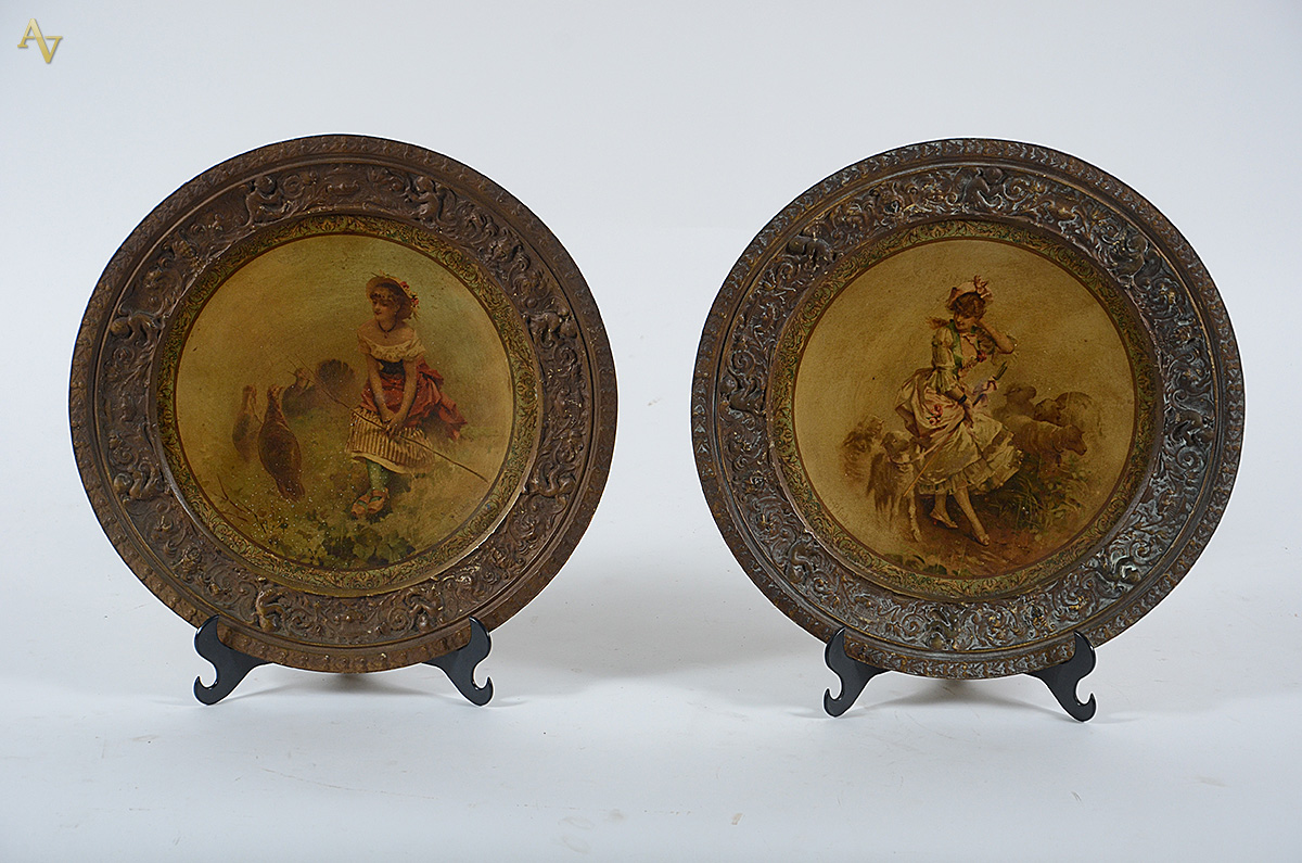 Par de medalhões de metal decorados com figuras de camponesas em...