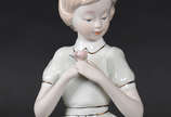 Estatueta de porcelana representando menina com... - Estatueta de porcelana representando menina com flor .