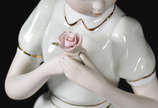 Estatueta de porcelana representando menina com... - Estatueta de porcelana representando menina com flor .