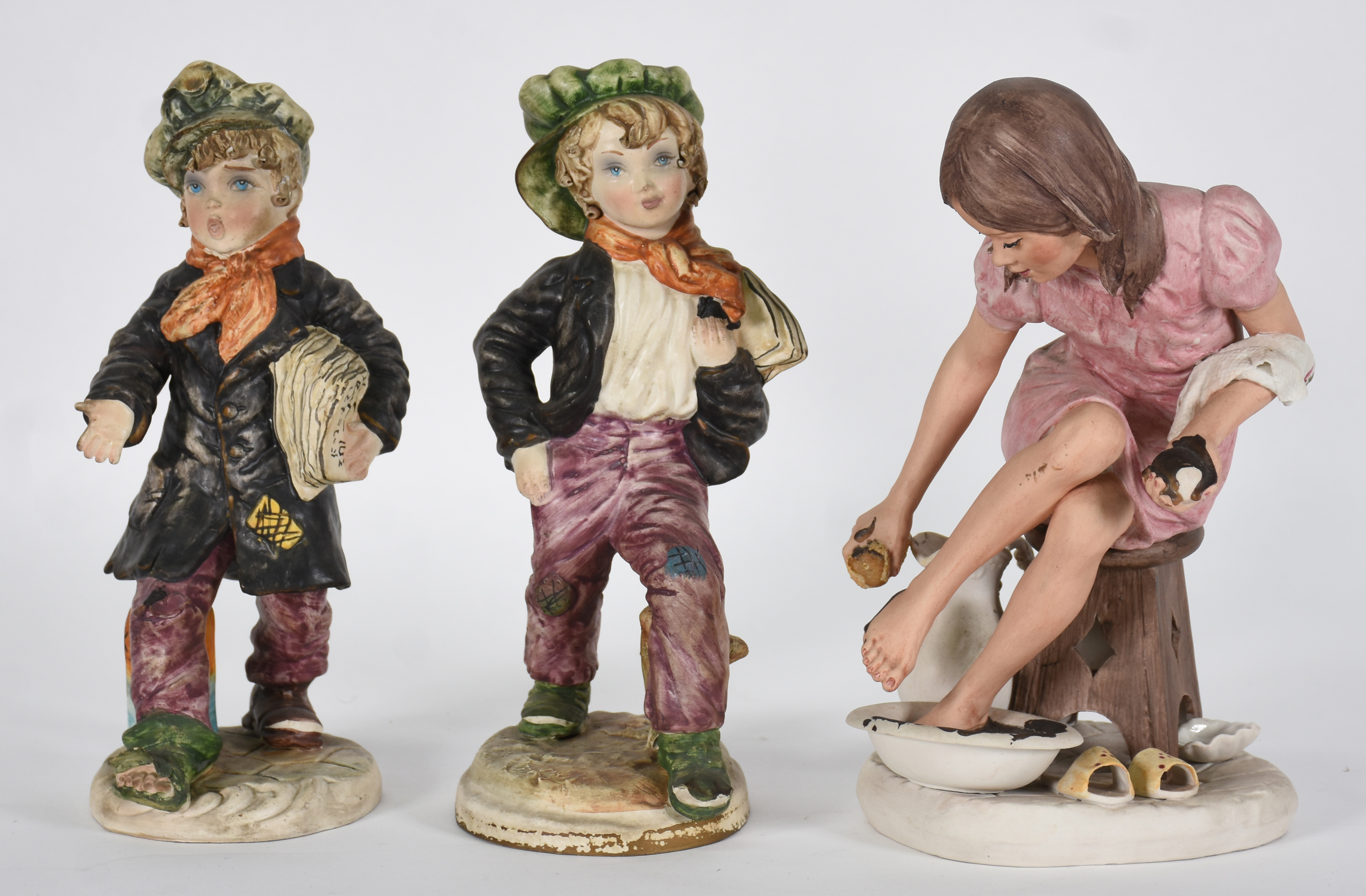 Três estatuetas , de porcelana sendo , 2 representando meninos e 1... - foto 1 de 8