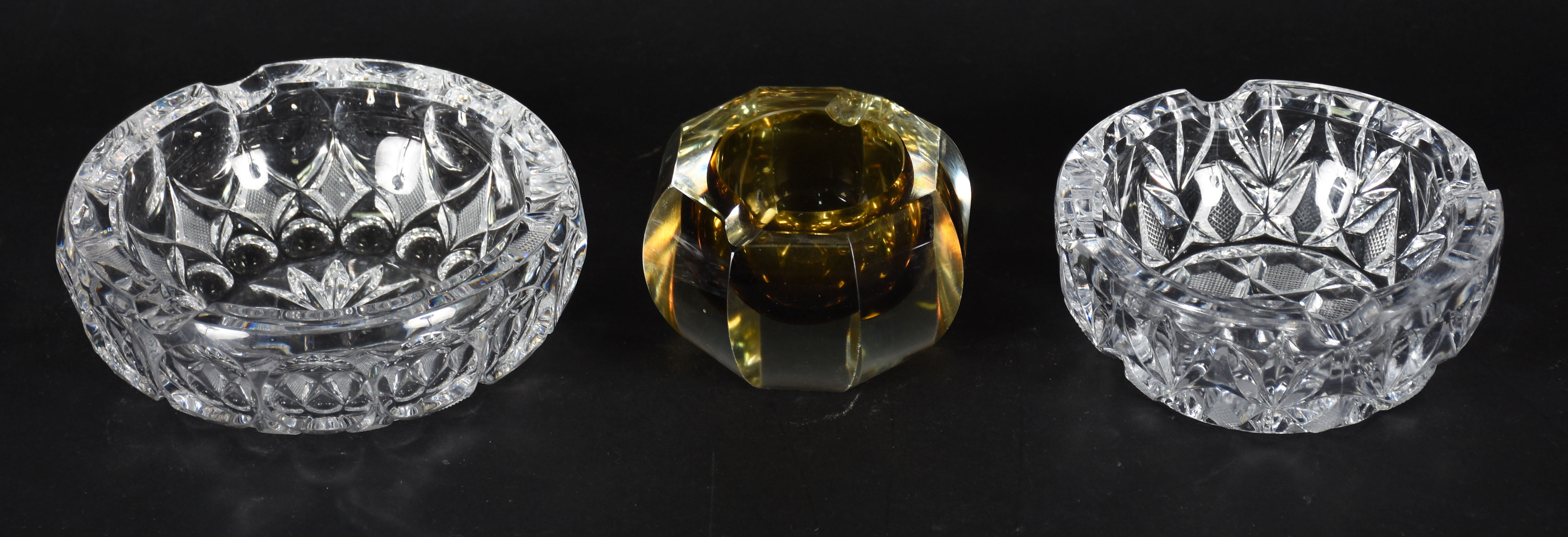 Três cinzeiros de cristal, sendo um na cor âmbar facetado e dois... - foto 1 de 3