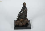 Escultura de terracota representando menina sen... - Escultura de terracota representando menina sentada em rocha. Altura 24 cm.