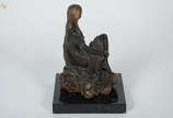Escultura de terracota representando menina sen... - Escultura de terracota representando menina sentada em rocha. Altura 24 cm.