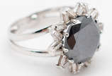Brilhante negro natural, de 6.99 ct, montado em... - Brilhante negro natural, de 6.99 ct, montado em ouro branco 18 k, guarnecido por 20 brilhantes brancos, lapidação baguette de 0,04 ct cada um. A...