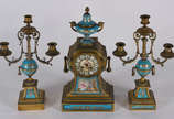 Terno frances de bronze e porcelana turquesa de... - Terno frances de bronze e porcelana turquesa decorada com figuras infantis e anjo em policromia, composto de relógio (faltando um ponteiro) e pa...