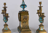 Terno frances de bronze e porcelana turquesa de... - Terno frances de bronze e porcelana turquesa decorada com figuras infantis e anjo em policromia, composto de relógio (faltando um ponteiro) e pa...
