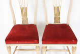 Par de cadeiras de madeira nobre patinadas em d... - Par de cadeiras de madeira nobre patinadas em decapê com realces dourados, assentos estofados e forrados de veludo vermelho com tacheados.