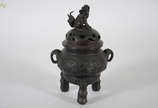 Incensório de bronze chinês com tampa em forma ... - Incensório de bronze chinês com tampa em forma de cão de fó, acompanha peanha de madeira. Altura 44 cm.