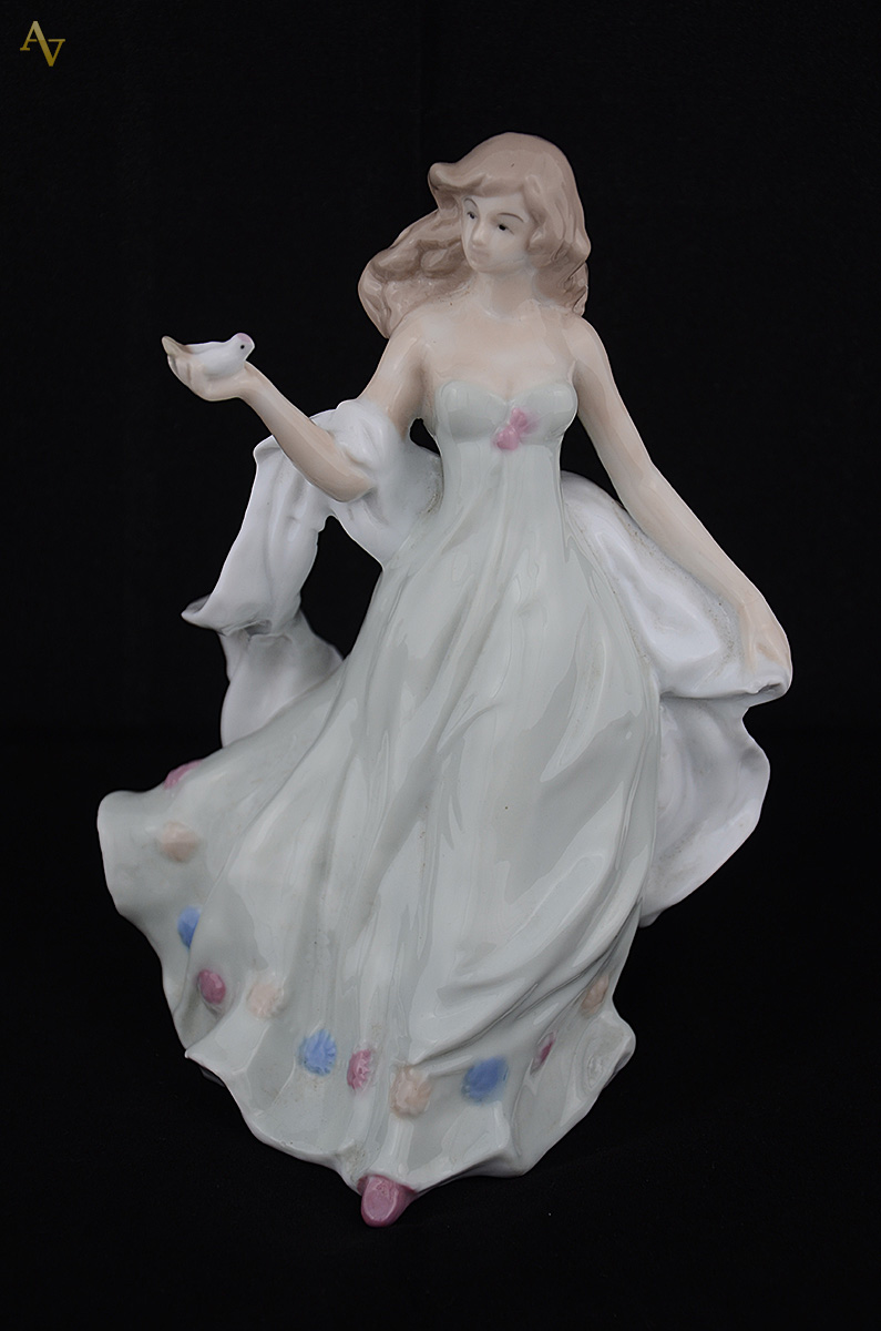 Estatueta de porcelana espanhola representando moça com pássaro... - foto 1 de 2