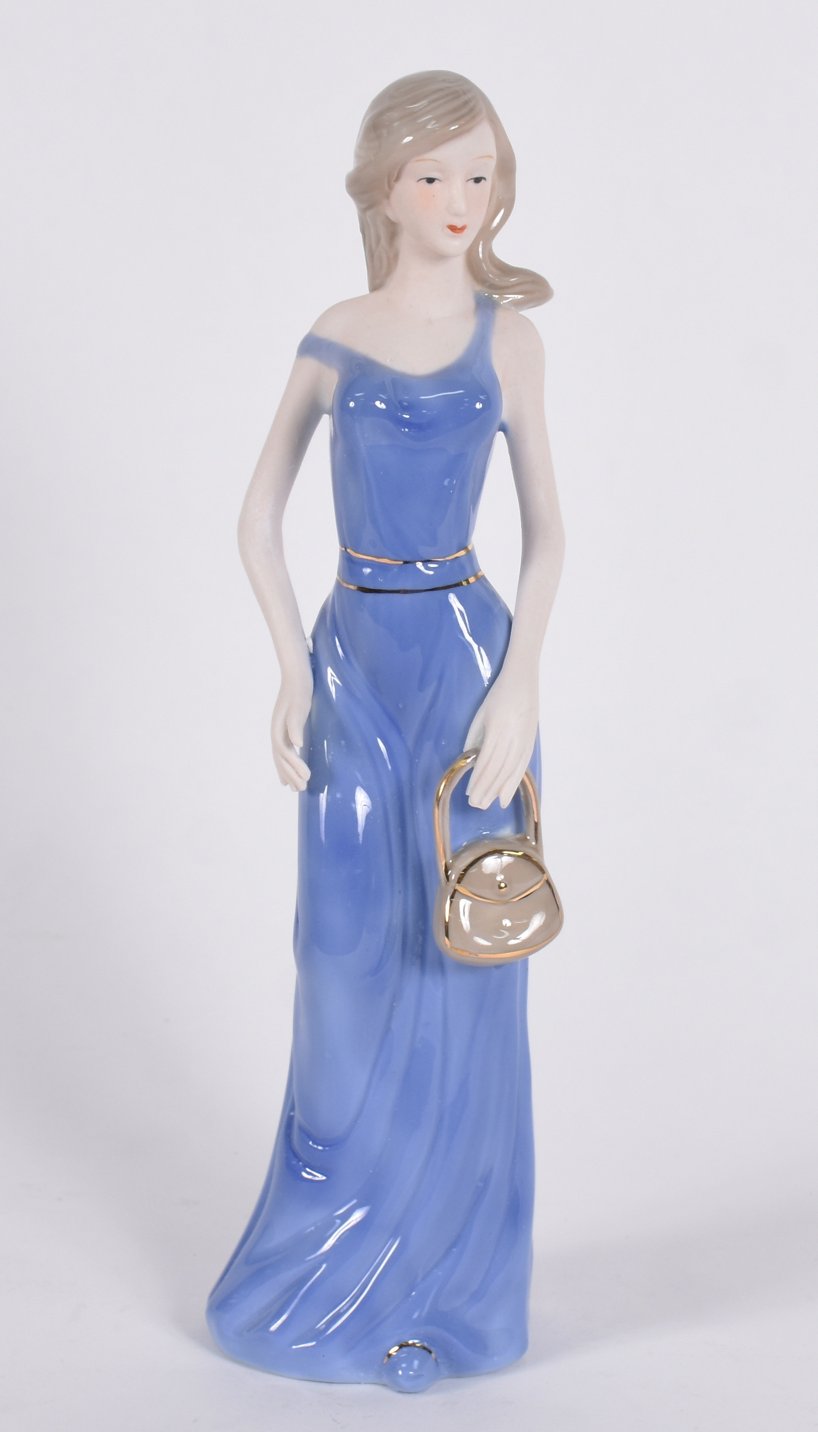 Escultura de porcelana representando mulher com bolsa. - foto 1 de 4