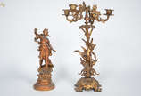 Conjunto com duas peças de petit bronze sendo c... - Conjunto com duas peças de petit bronze sendo candelabro para 4 luzes (altura 52 cm) e escultura representando figura feminina (altura 36 cm).