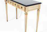 Mesa de encostar de madeira nobre em decapé, du... - Mesa de encostar de madeira nobre em decapé, duas gavetas, pernas cilíndricas e tampo de mármore preto.