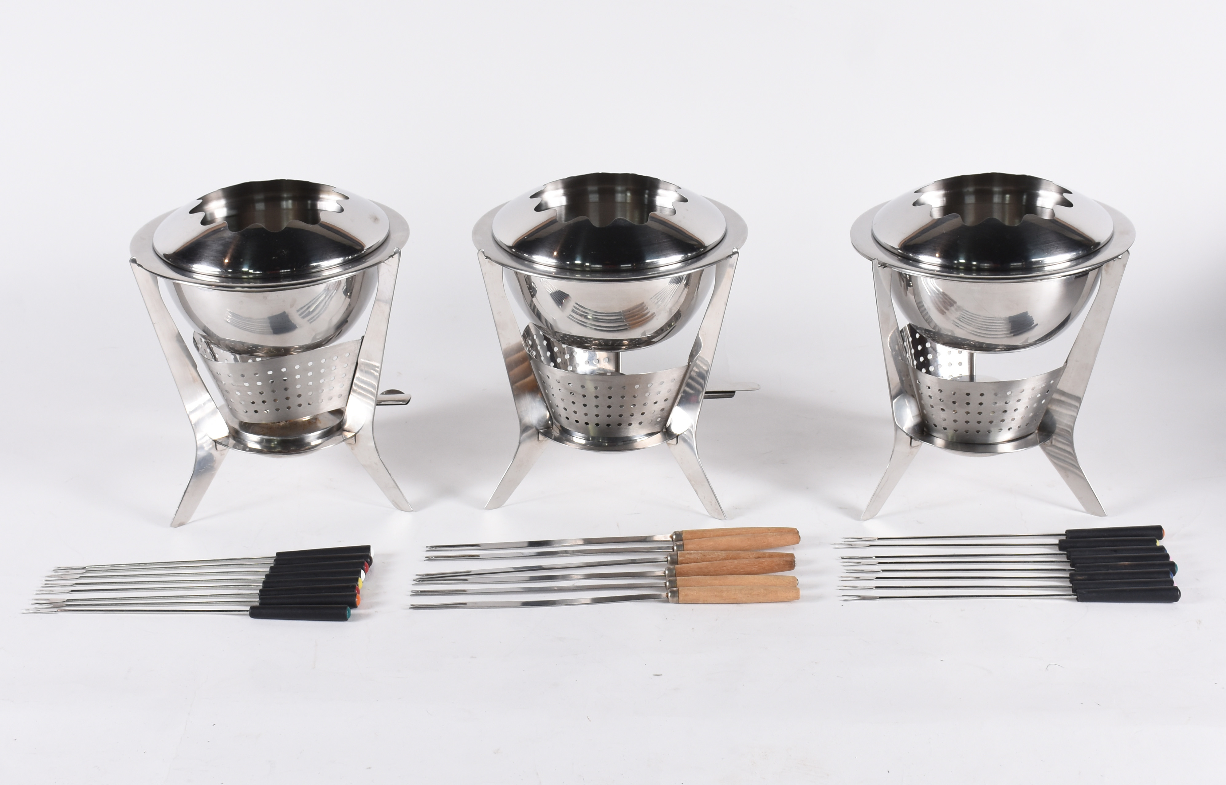 Três panelas de fondue de metal com fogareiros e espetos. - foto 1 de 4