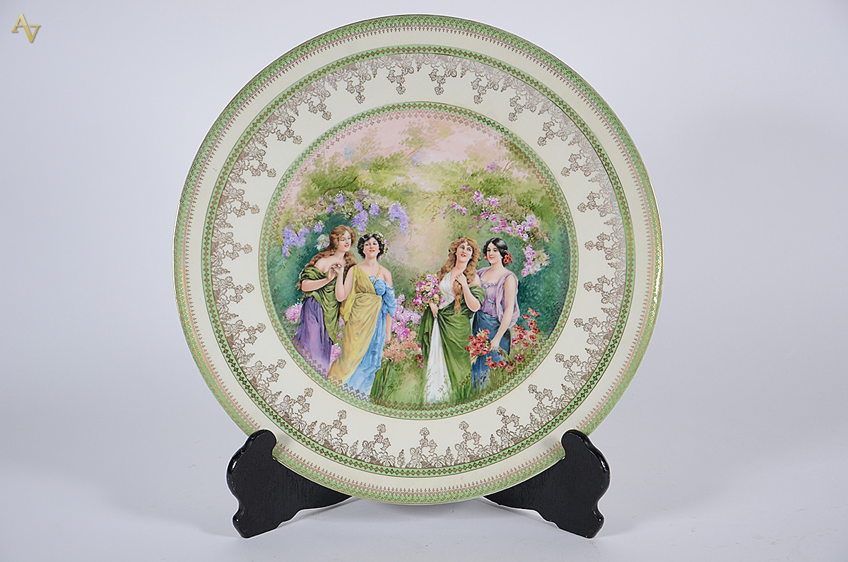 Medalhão de porcelana com figuras femininas em policromia, borda com...
