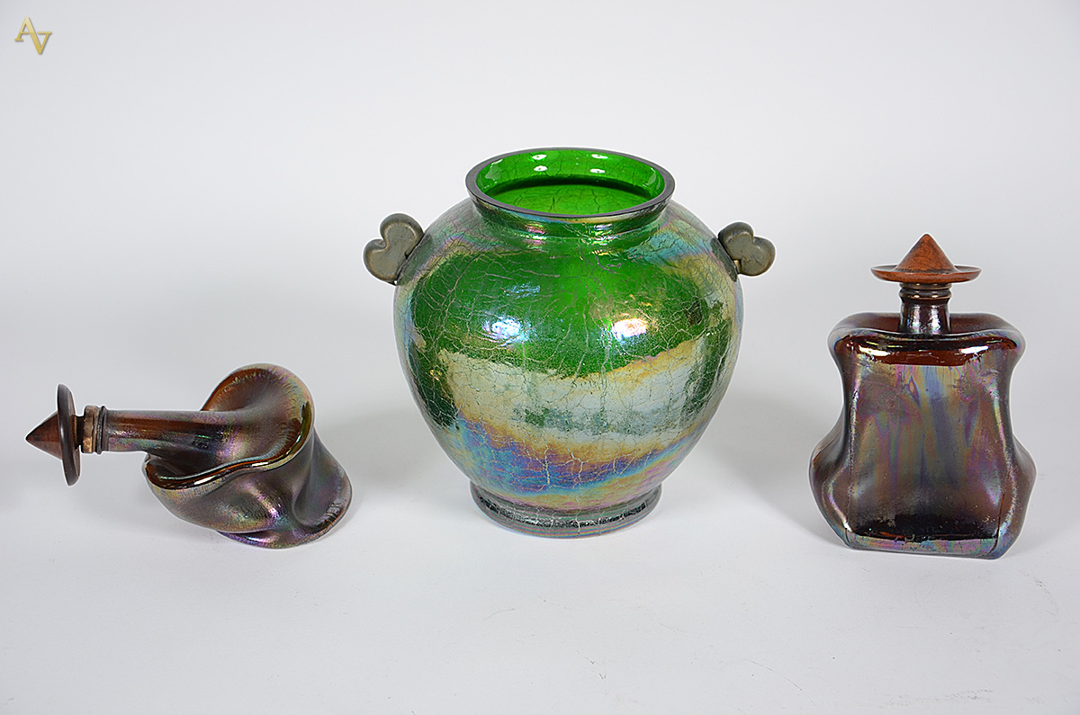 Três peças de vidro decorativas, sendo: vaso verde e par de garrafas...
