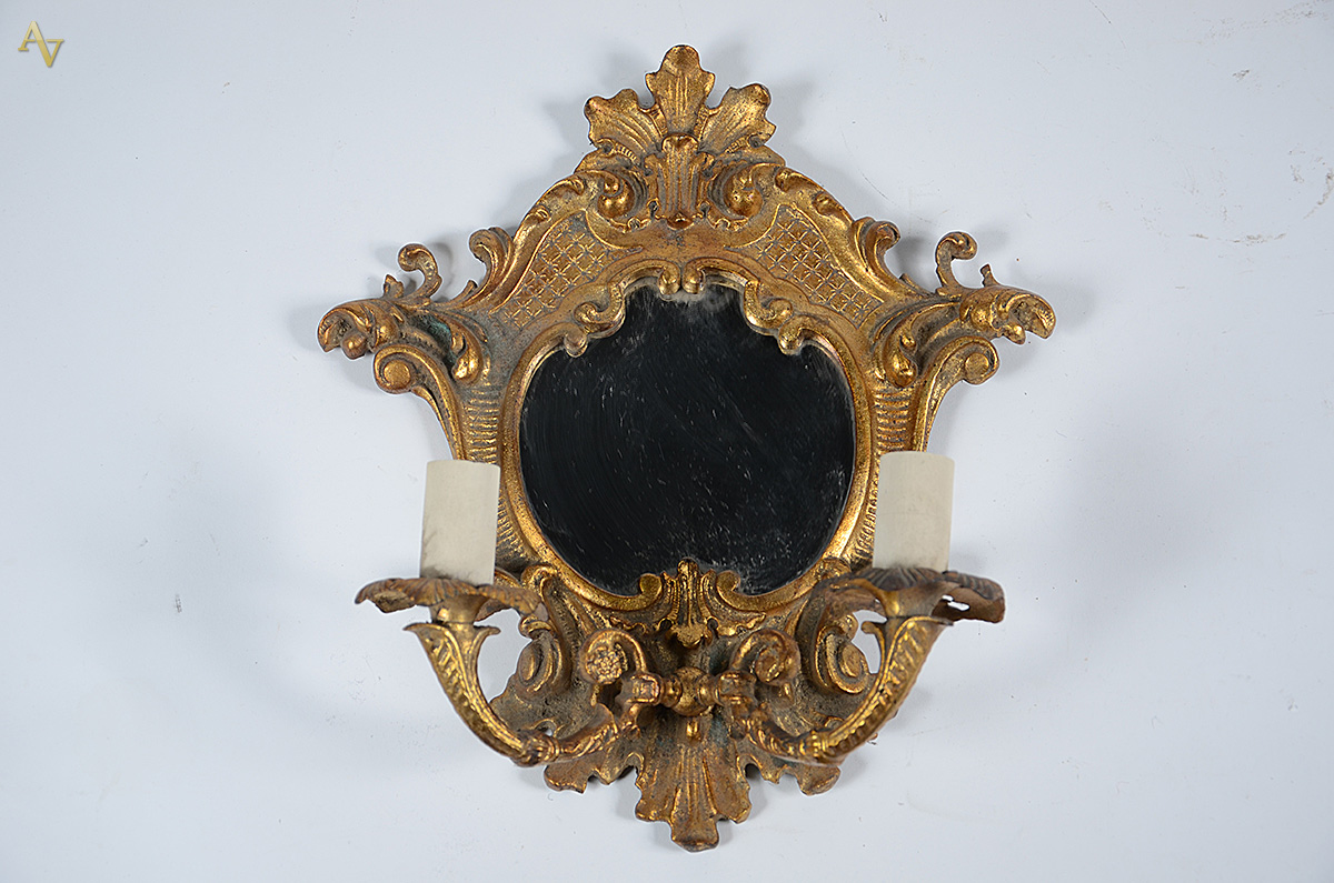 Aplique de metal dourado com espelho central. Altura 38 cm.