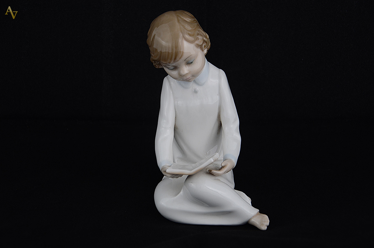Escultura de porcelana representando menina lendo. Altura 15 cm. - foto 1 de 3