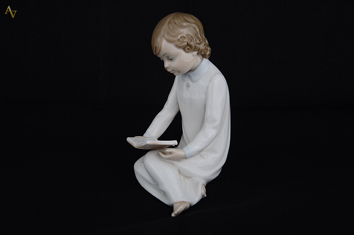 Escultura de porcelana representando menina lendo. Altura 15 cm. - foto 2 de 3