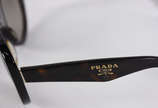 Óculos de sol da marca Prada, no estojo. - Óculos de sol da marca Prada, no estojo.