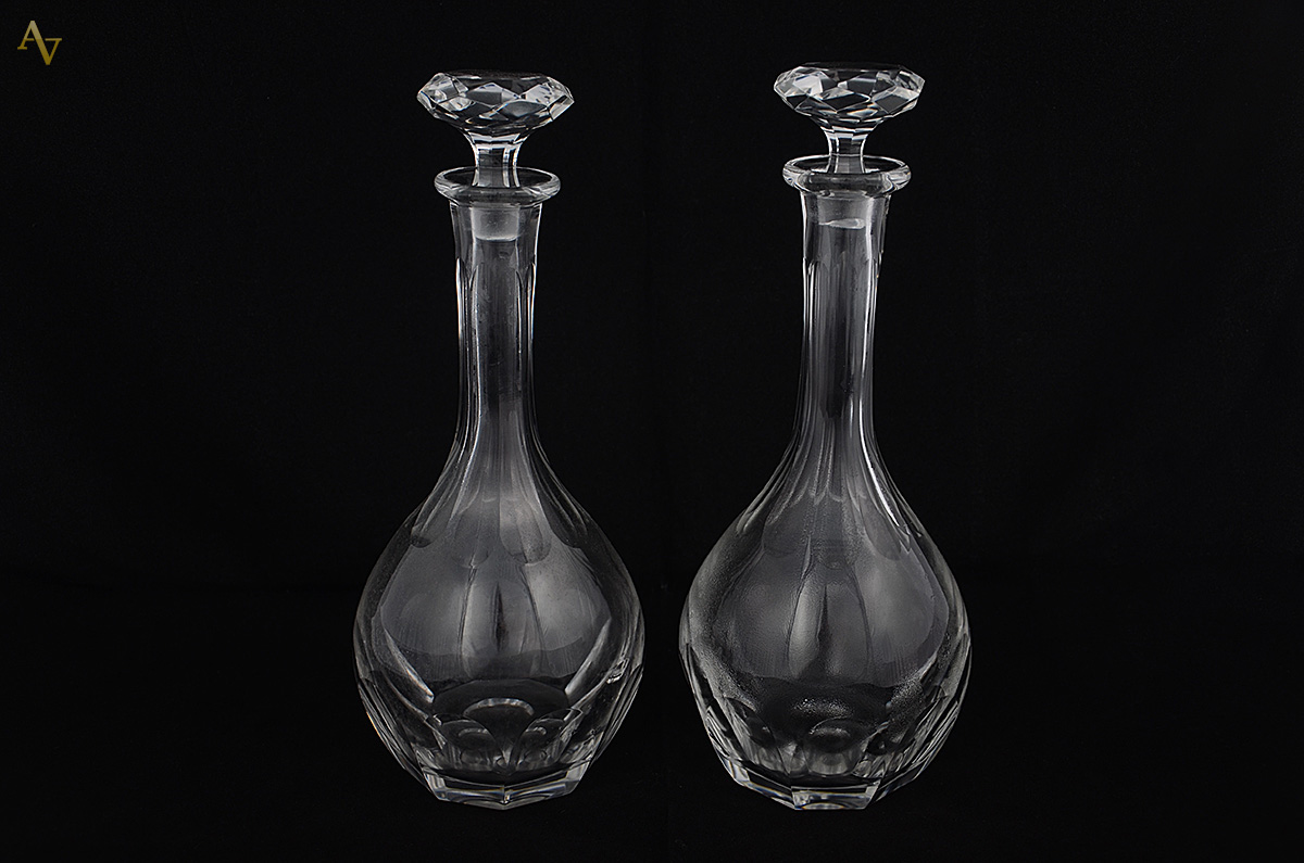 Duas garrafas de cristal europeu facetado. Alturas 29 e 32 cm.
