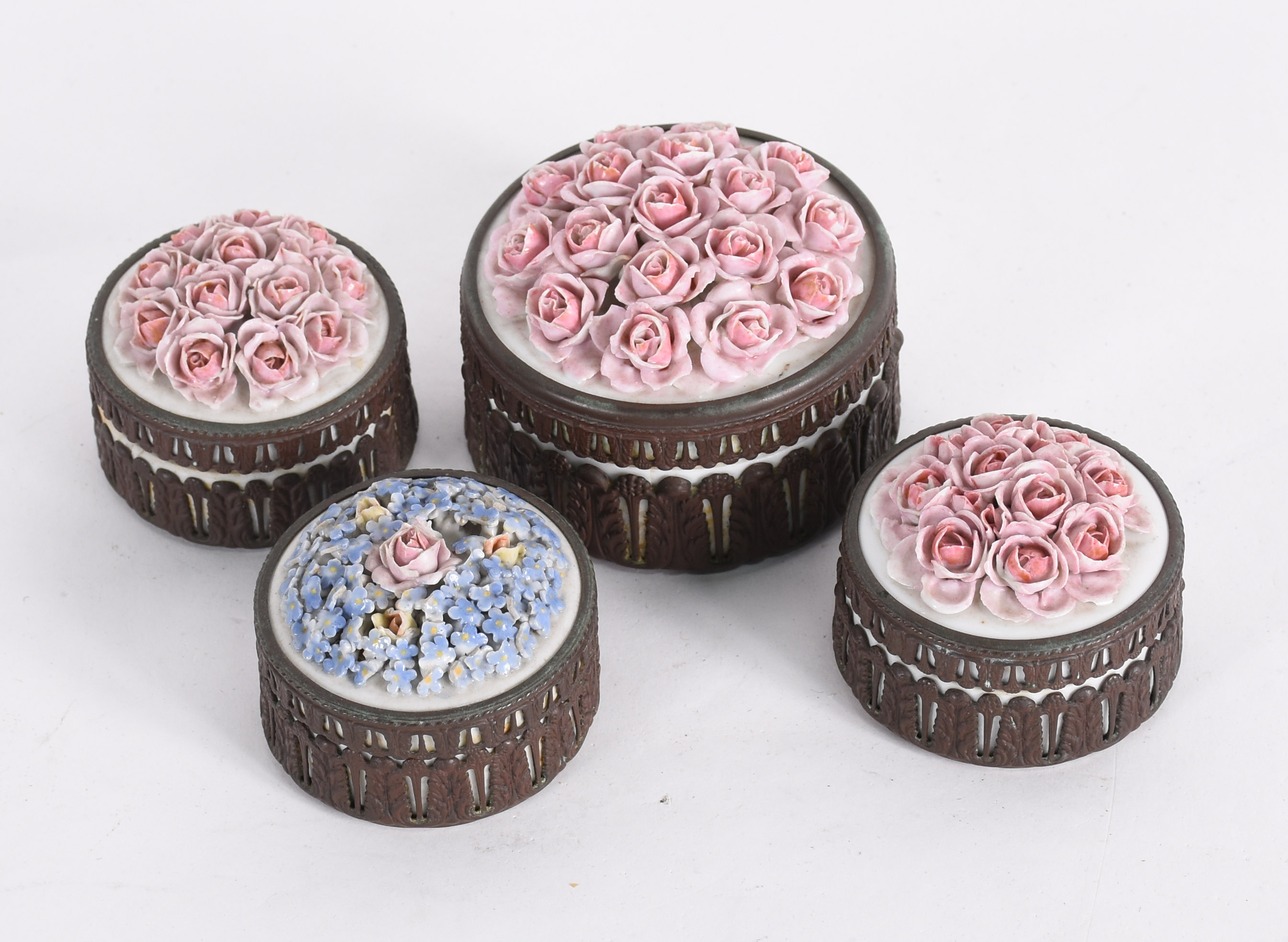 Quatro caixinhas de porcelana com tampas tendo flores policromadas em... - foto 1 de 6