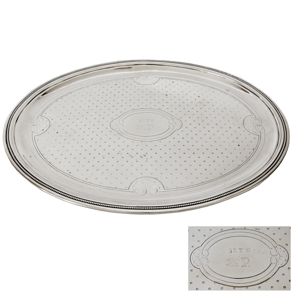 Travessa oval em metal espessurado a prata, apresentando trabalhos em...