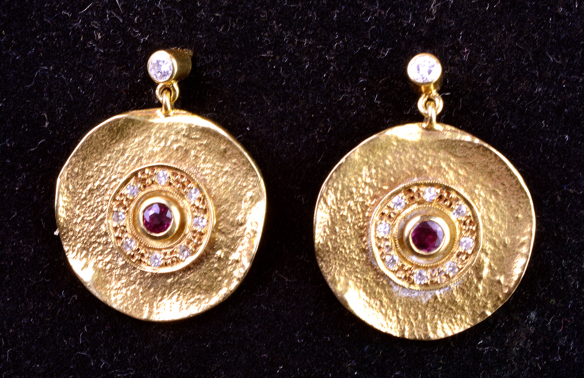 Par de brincos em ouro amarelo 18 k em formato circular, apresentando...