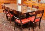 Sala de janta em madeira nobre brasileira compo... - Sala de janta em madeira nobre brasileira composta por mesa e oito cadeiras com estofado em couro na cor vermelha e tampo encimado de vidro.