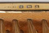 Lote constando duas peças em metal sendo: uma e... - Lote constando duas peças em metal sendo: uma escova de cabelo manufatura Mapping e Webb, e uma espátula abre cartas com cabo em baquelite decor...