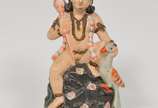 Estatueta confeccionada em terracota policromad... - Estatueta confeccionada em terracota policromada representando figura indiana. Peça apresenta desgastes na policromia. <br><br>Lote não exposto ...