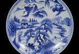 Medalhão em porcelana japonesa, decorado em azu... - Medalhão em porcelana japonesa, decorado em azul com paisagens e borda estilizada.<br>Fornos de Arita. <br>Séc. XX<br><br>Lote não exposto cod.L5