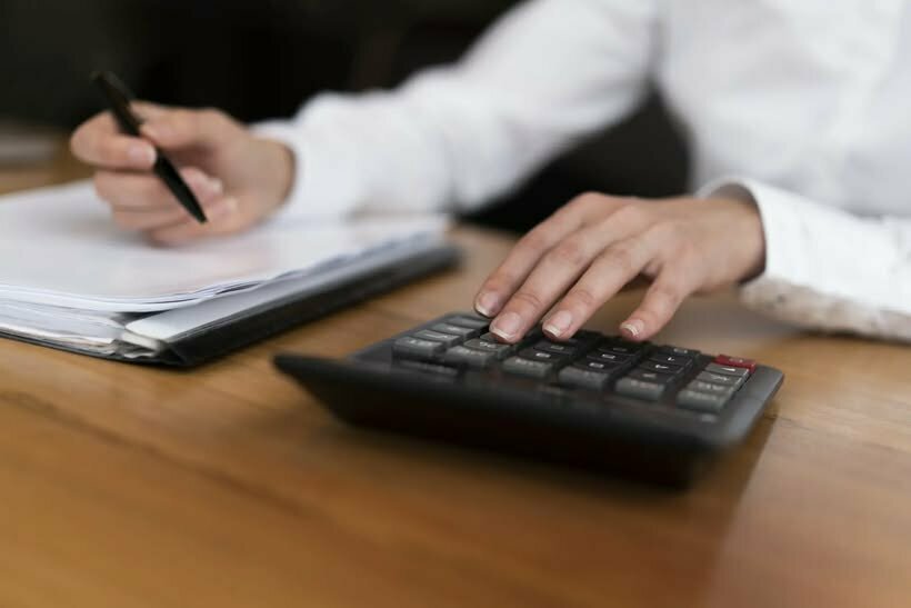 Unrecognisable professional worker typing calculator
