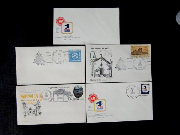 EUA, lote com 04 FDC`s com carimbos comemorativos déc. 70/80 + envelope dos correios dos EUA.