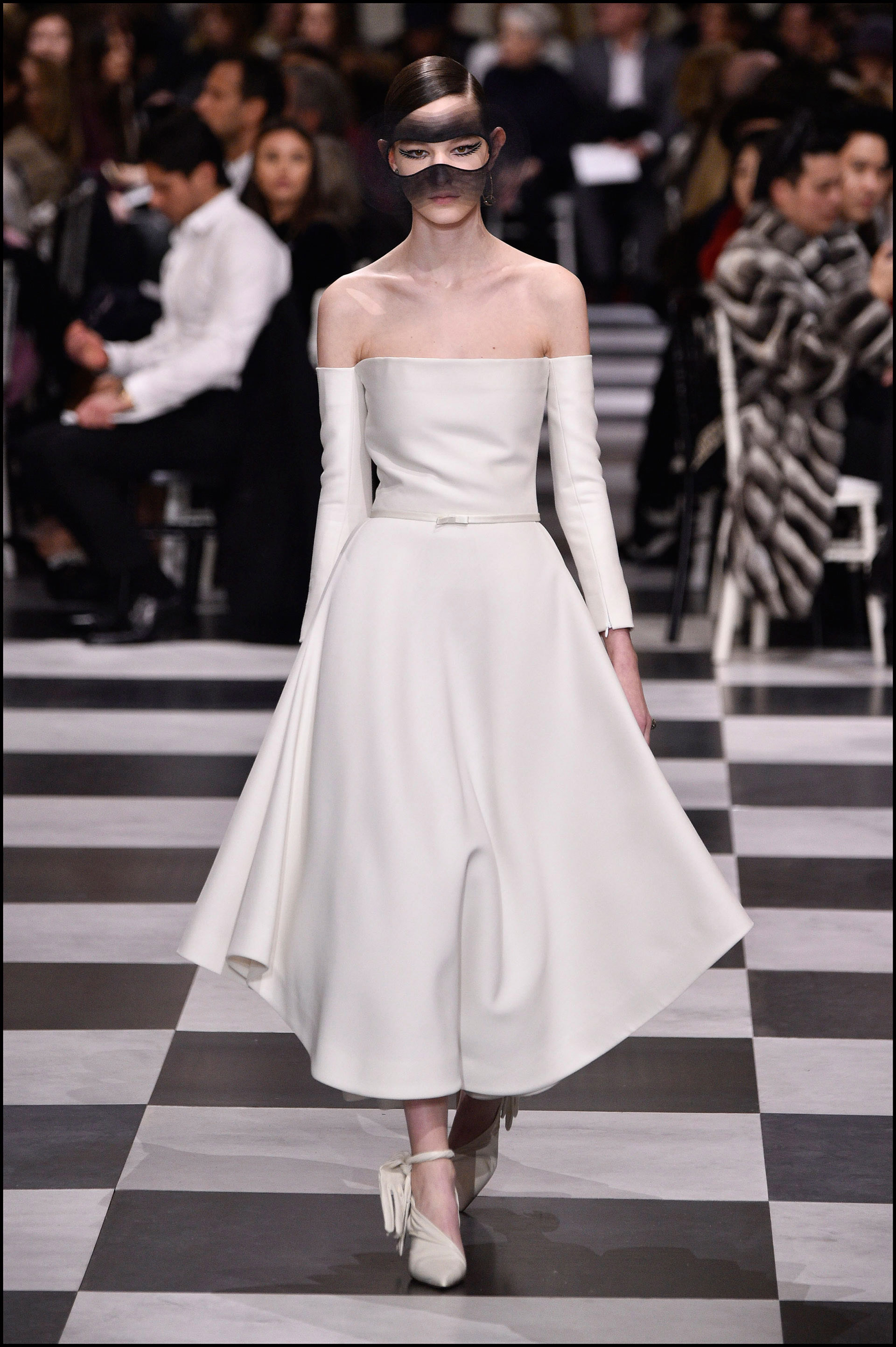Vestido all white, con la cintura ceñida y escote of the shoulders.