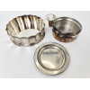 <p>Lote com 3 porta garrafas de metal prateado, sendo 1 St. James com 15 cm diâm, 1 Eberle Silverplated, com rolha, medindo 15 cm de di diâm e 1 menor com 11 cm de diâm</p>