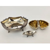 <p>Lote com 3 peças de metal prateado, contendo 1 centro de mesa, 1 petisqueira e 1 pequeno saleiro - medindo 19, 15 e 9 cm de larg</p>