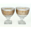 <p>Conjunto de duas elegantes compoteiras de pé alto, de cristal transparente e espesso com lapidação bico de jaca. Decoradas com faixa central dourada gravada, apresentando ricas cenas em relevo inspiradas na Grécia Antiga. - Diâm 18 x 20 cm alt</p>